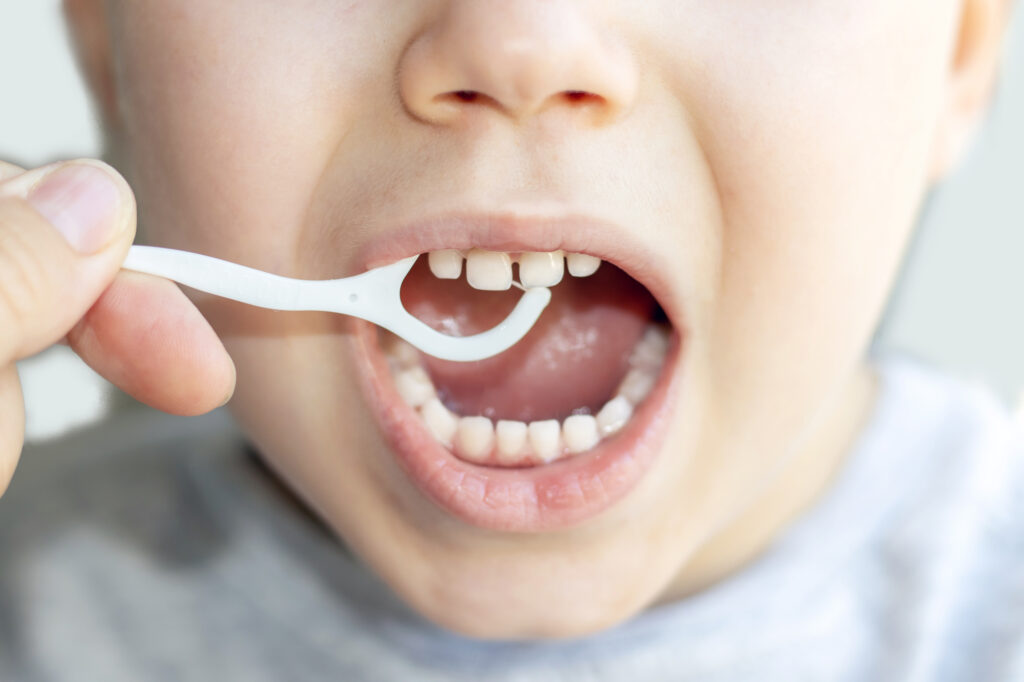 Toddler flossing teeth. 