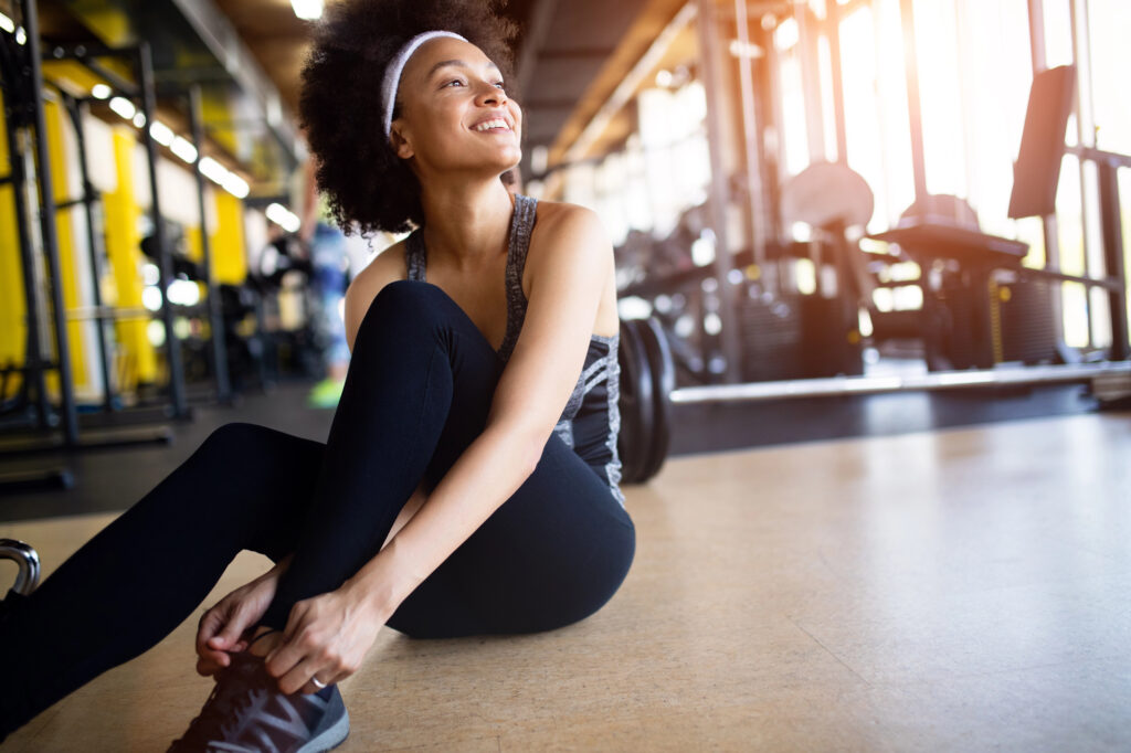 Young woman at the gym exercising with healthy smile. 