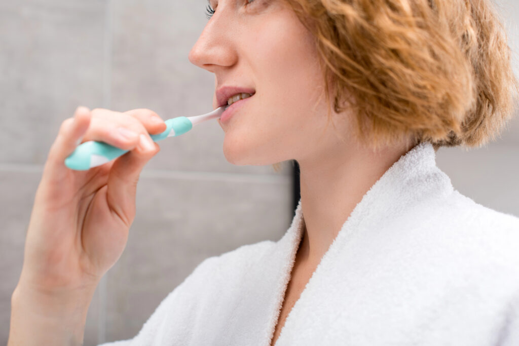 Woman brushing teeth.